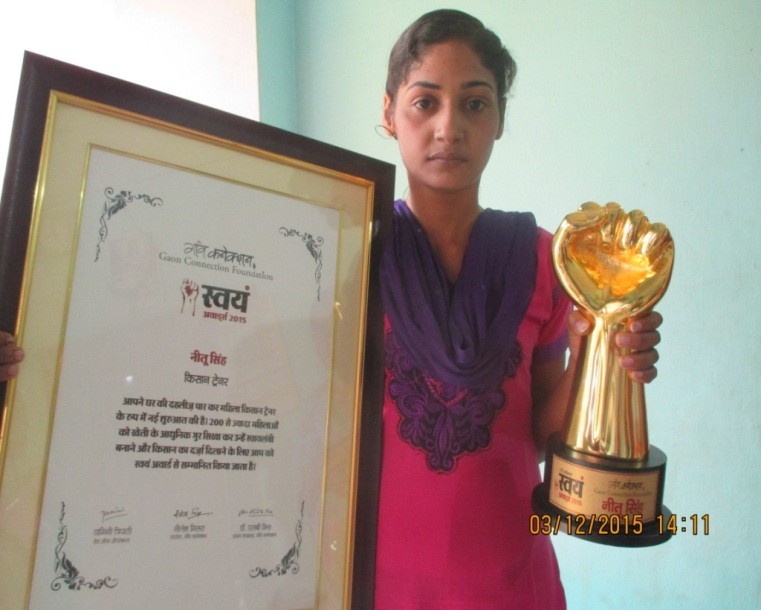 Kisan Trainer Neetu Singh displaying the official framed Gaon Connection Swayam Award certificate and golden trophy