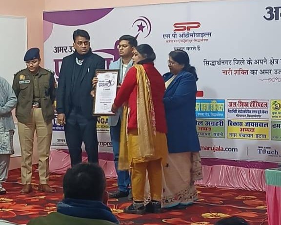 Amar Ujala Prathama Award stage felicitation ceremony presenting framed award certificate to frontline worker Ms. Sambhavati at District HQ Siddharthnagar